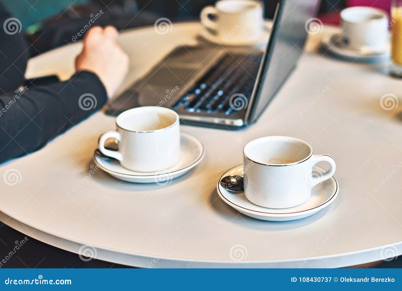 Beschäftigter Morgen mit verlorenem von leeren Kaffee- oder Teeschalen auf dem Tisch. Beschäftigter Morgen mit einem Laptop und viel leere Kaffee- oder Teeschalen auf dem Tisch