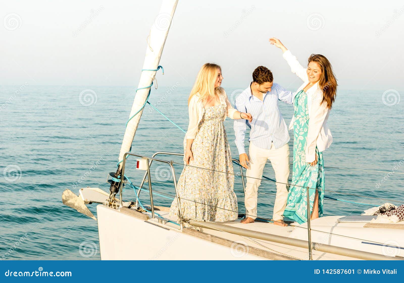 best friends dancing and having fun on exclusive luxury sailing boat - friendship travel concept with young people millenial