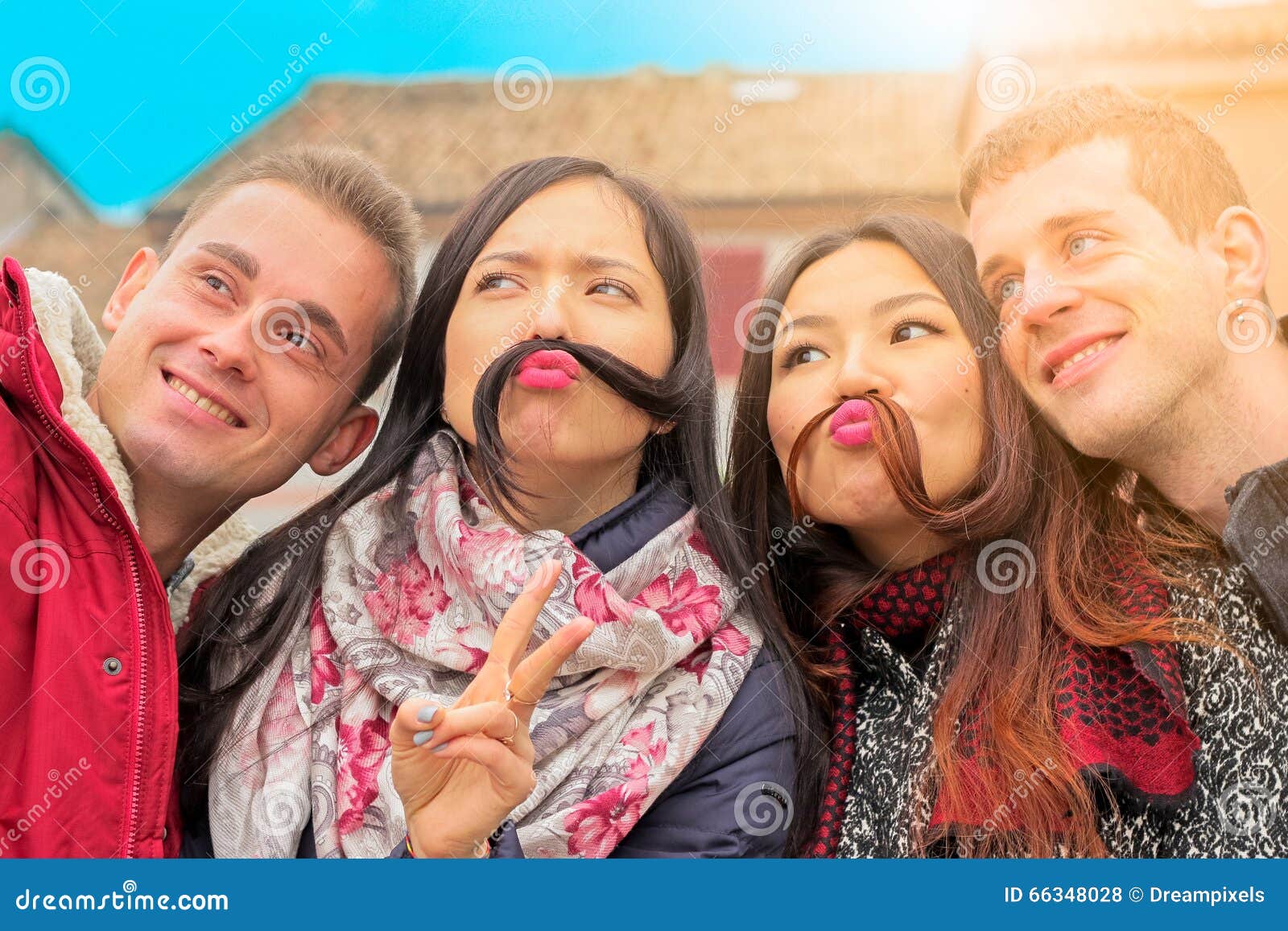 best friends get funny posing selfie close up portrait girls boys faces camera make mustache hair 66348028