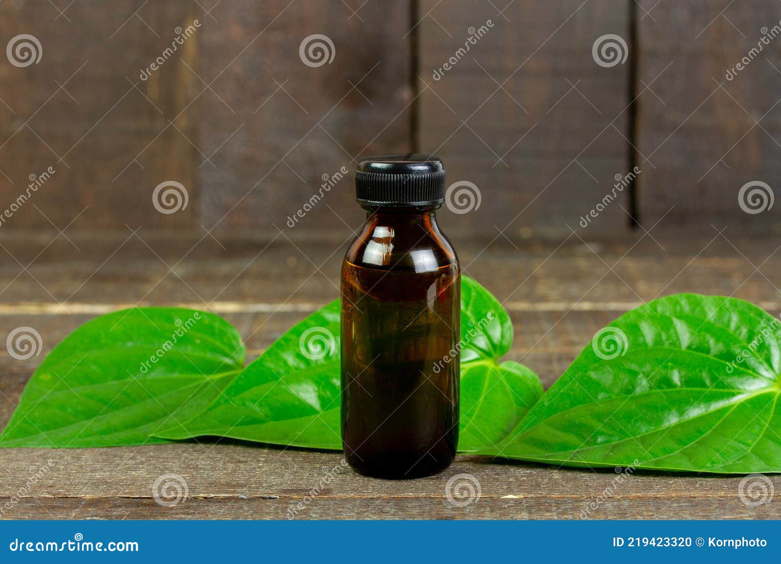 Betel Essential Oil in Bottle and Green Leaf on Wooden Table. Stock ...