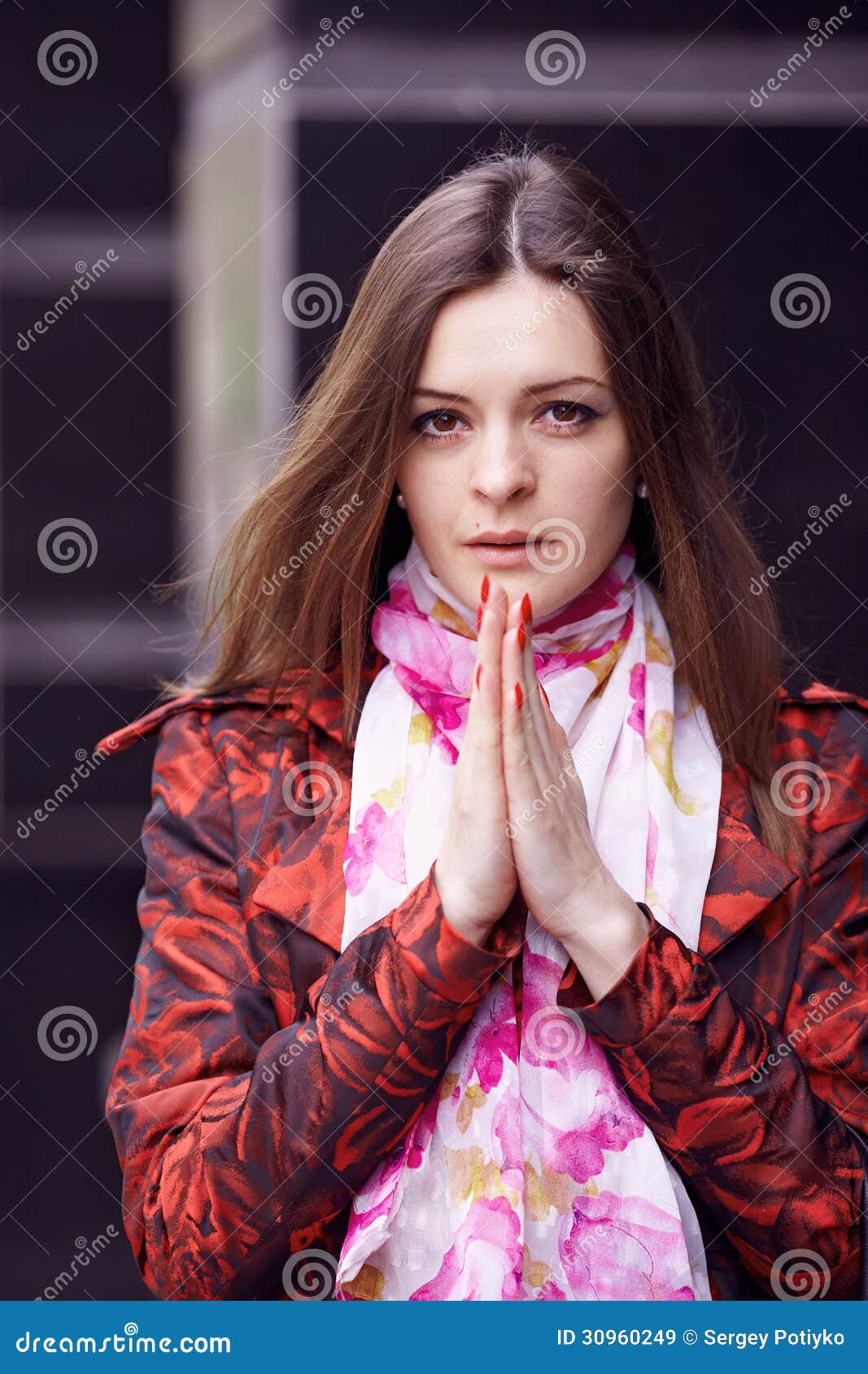 Betendes Mädchen. Schönes Mädchen in einem roten Mantel betend