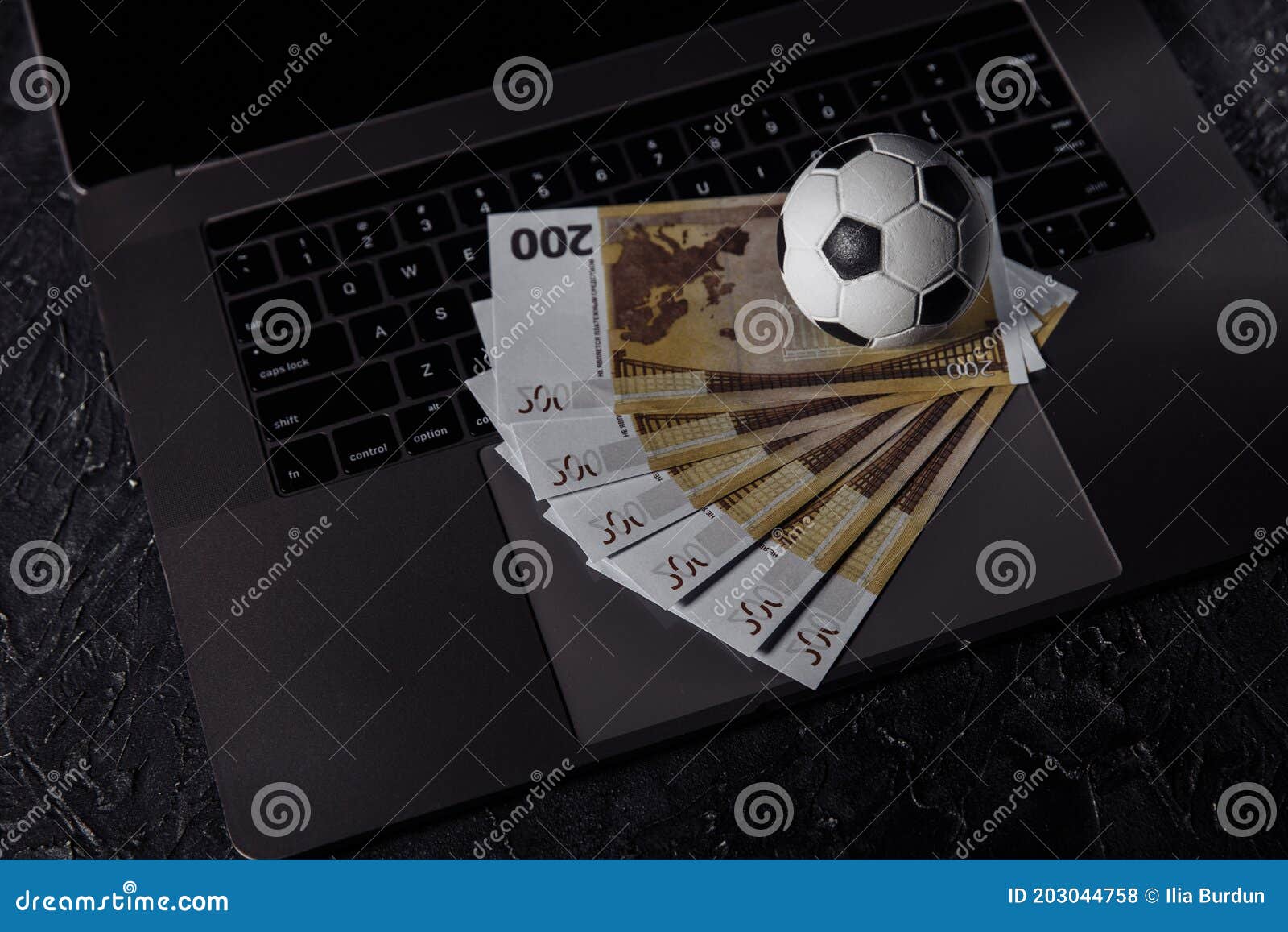 bets, sports betting, bookmaker. soccer ball and money on a laptop`s keyboard