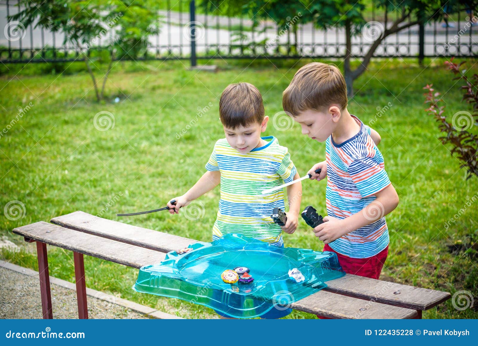 two boys playing with a beyblade, spinning top kid toy. popular