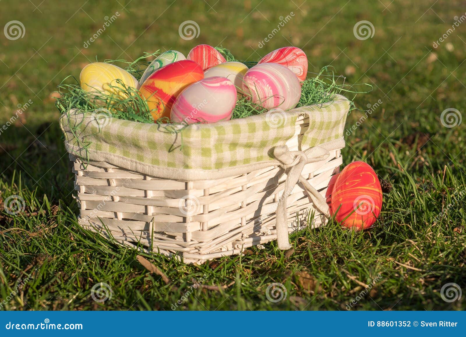 Biały Easter kosz na greenfield miejscu. Biały Easter kosz z kolorowymi jajkami na greenfield miejscu