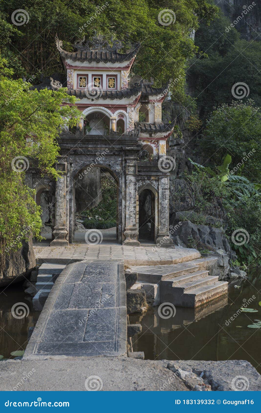 Premium Photo  Lone tourist with traditional vietnamese hat at bich dong  pagoda entrance gate, ninh binh vietnam, buddhist temple set amid jungle  and karst mountain range. traveling alone, keep social distancing.