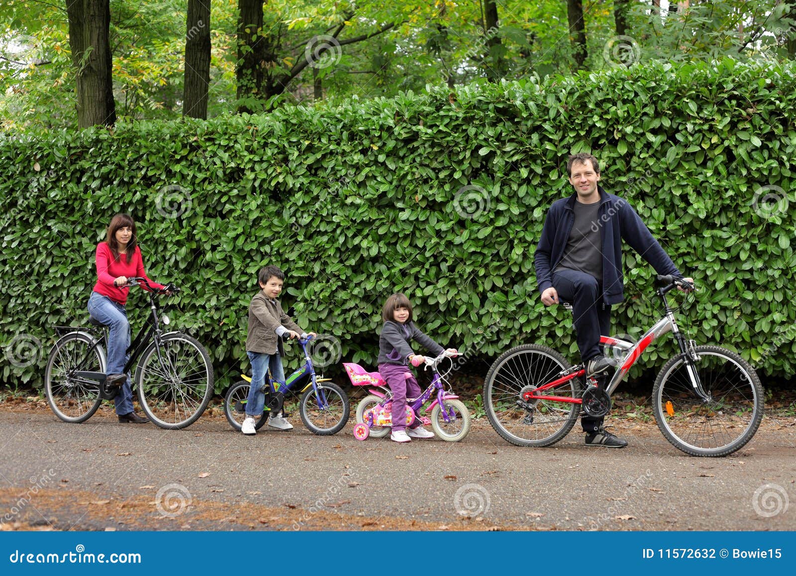 Bici feliz del montar a caballo de la familia en un parque