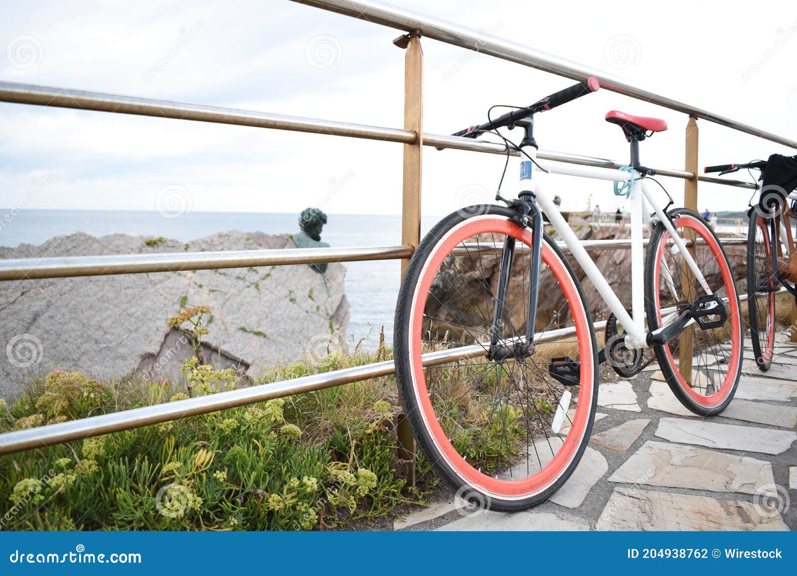 bicicleta aparcada sobre una barandilla con unas hermosas vistas al mar