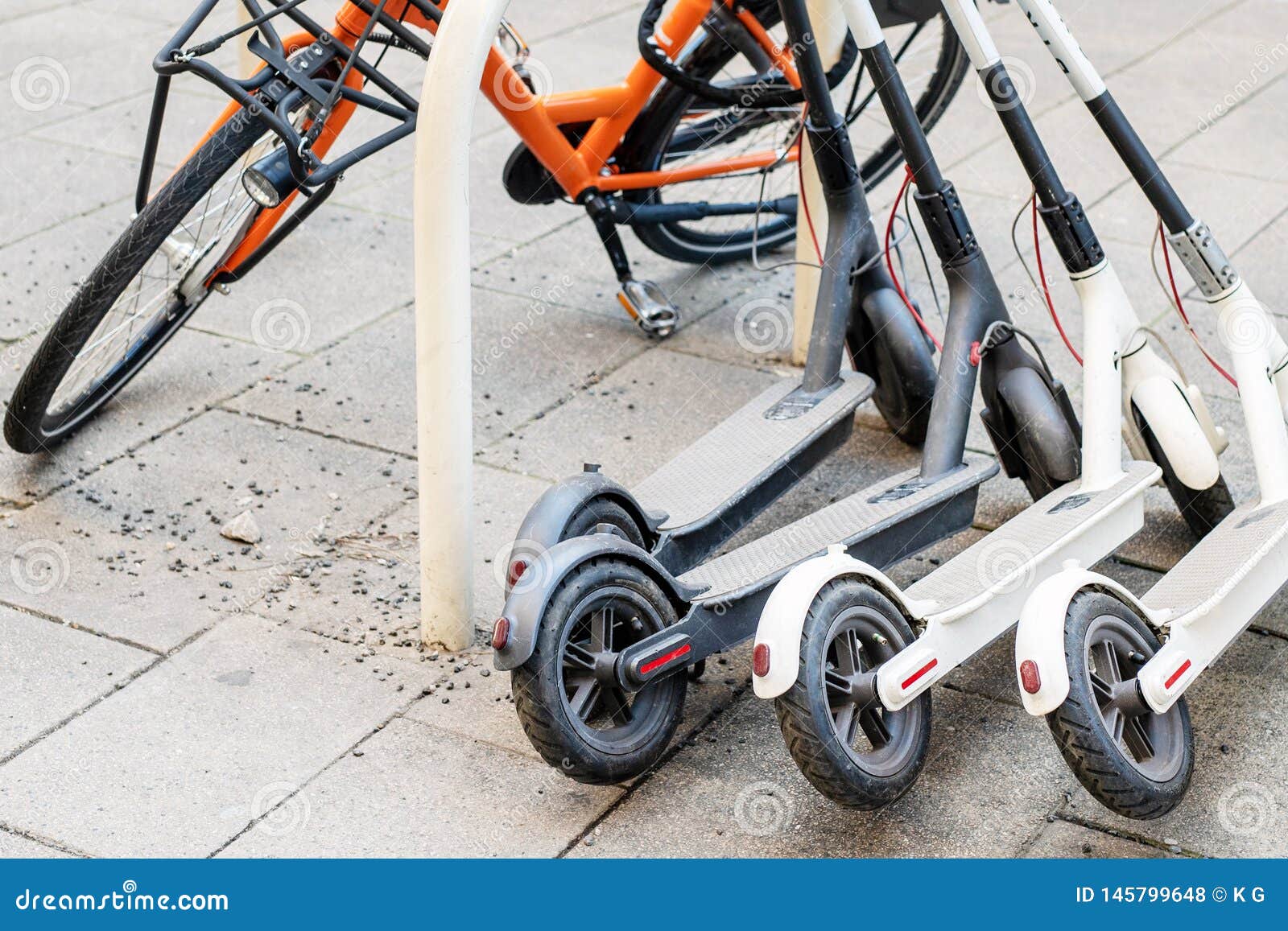 bicycle and electric scooters parked on city street. self-service street transport rental service. rent urban vehicle with