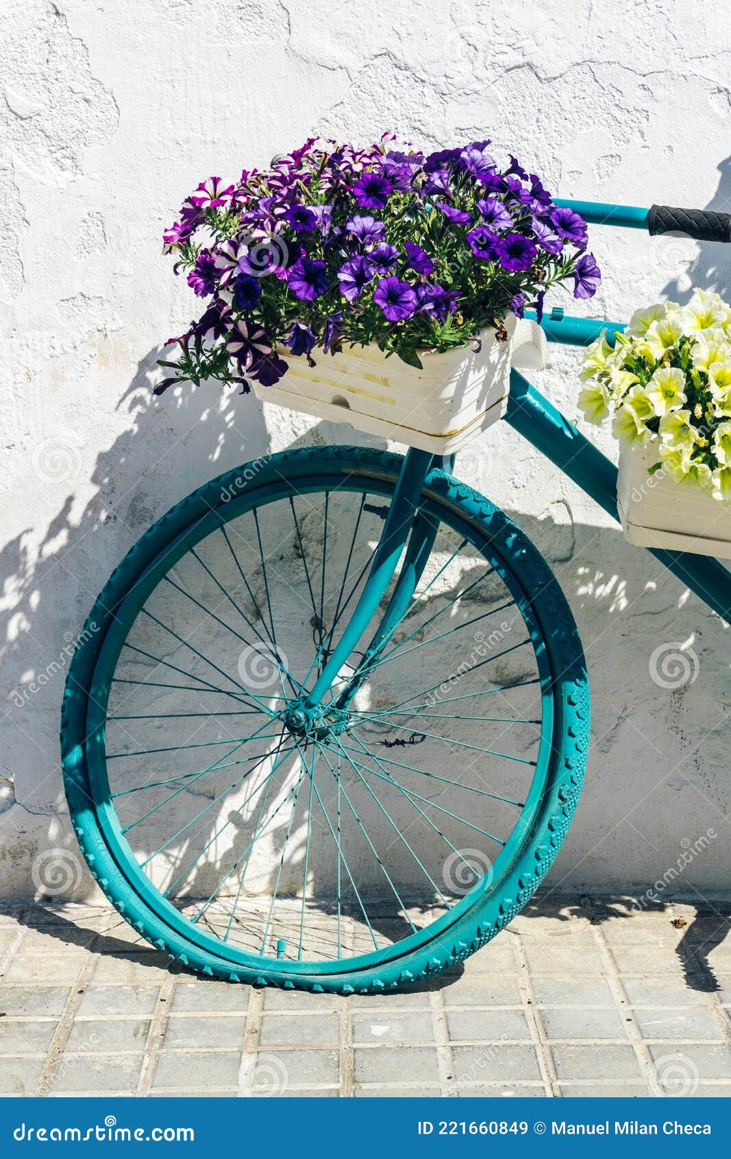 Bicycle with Flower Baskets Leaning Against an Old White Wall Stock