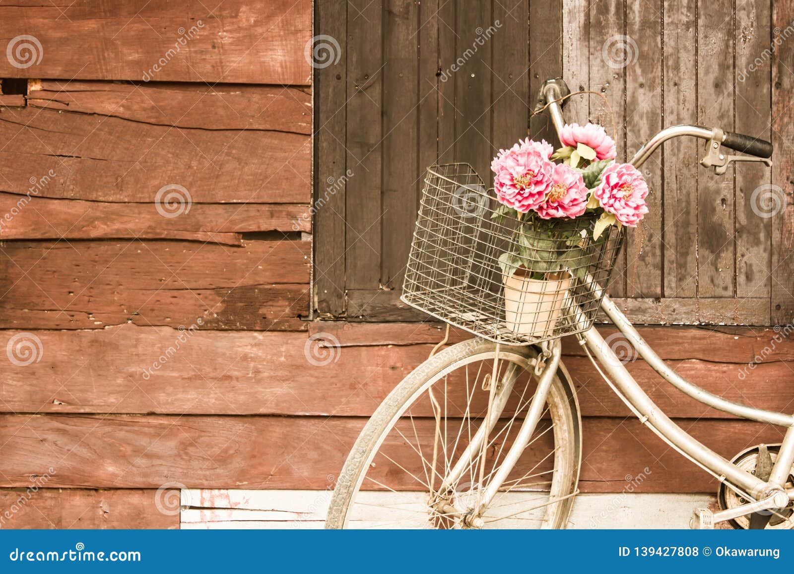 bicycles old vintage flowers in a basket. parked on the sidewall of the wooden house ideal for  work classic hoodie style