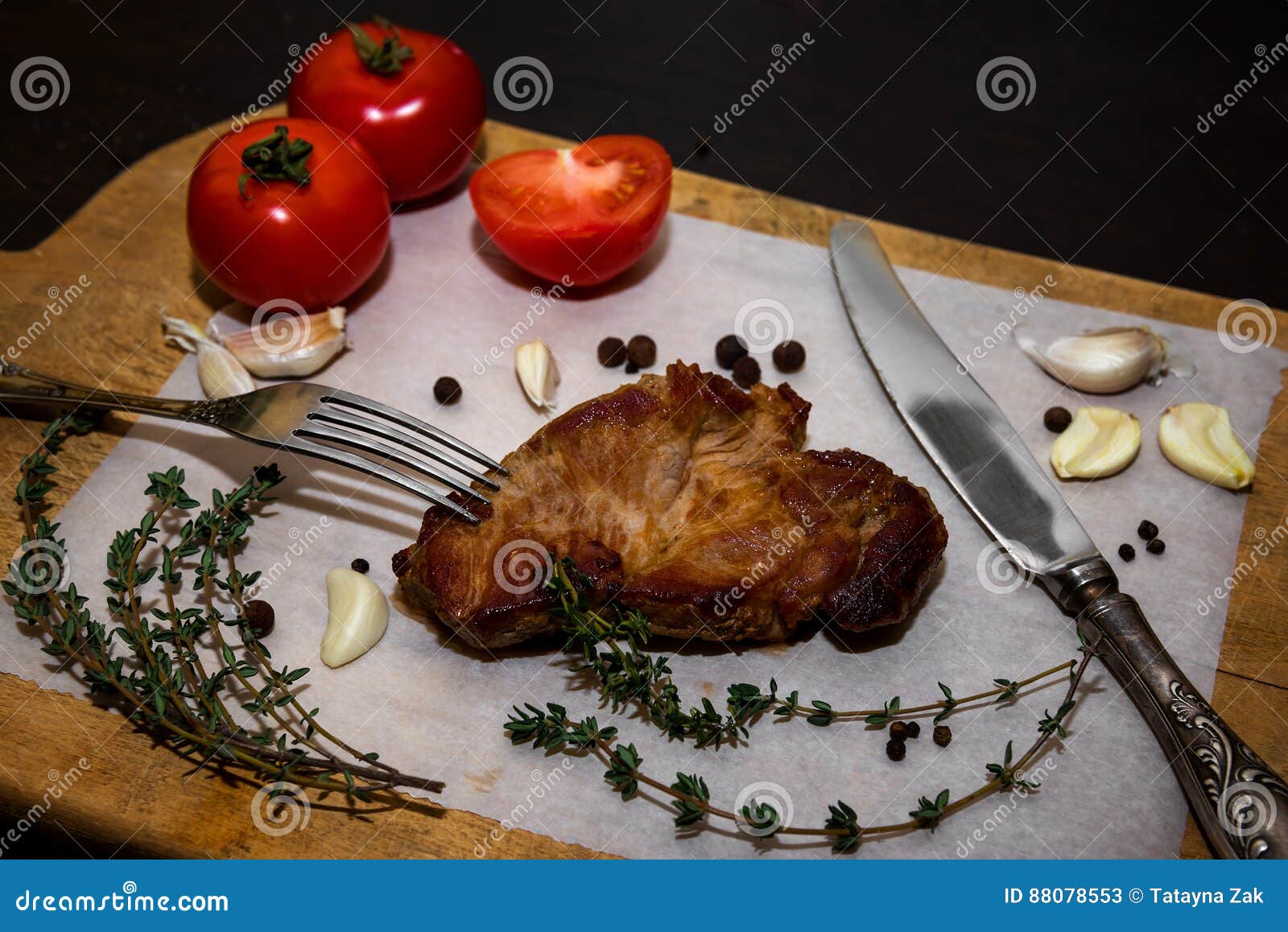 Bife suculento em uma placa de corte velha de madeira com especiarias e vegetais Em um fundo preto para o projeto do texto para menus do restaurante Fundo do alimento Foto horizontal