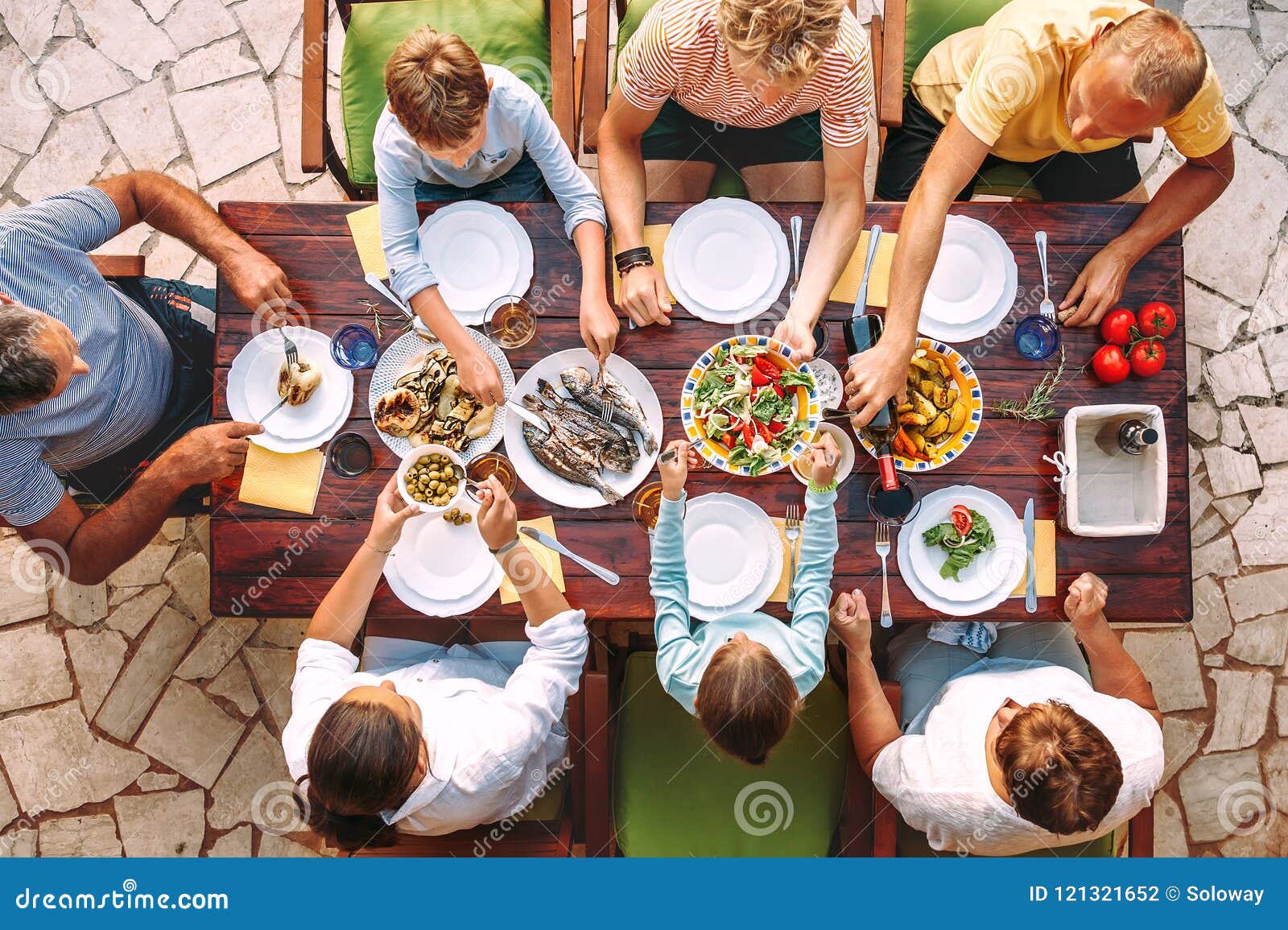 big family have a dinner with fresh cooked meal on open garden t