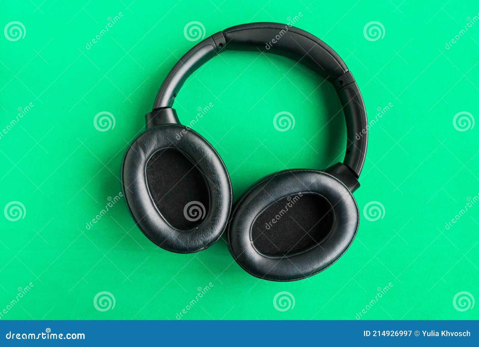 Big Modern Black Headphones Isolated on Bright Green Background. Stock