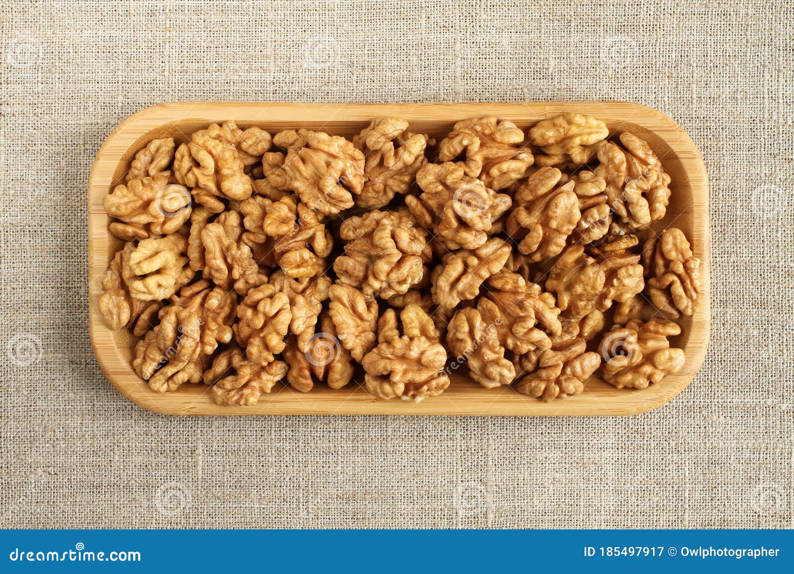 big peeled walnuts in bamboo plate on rough linen cloth