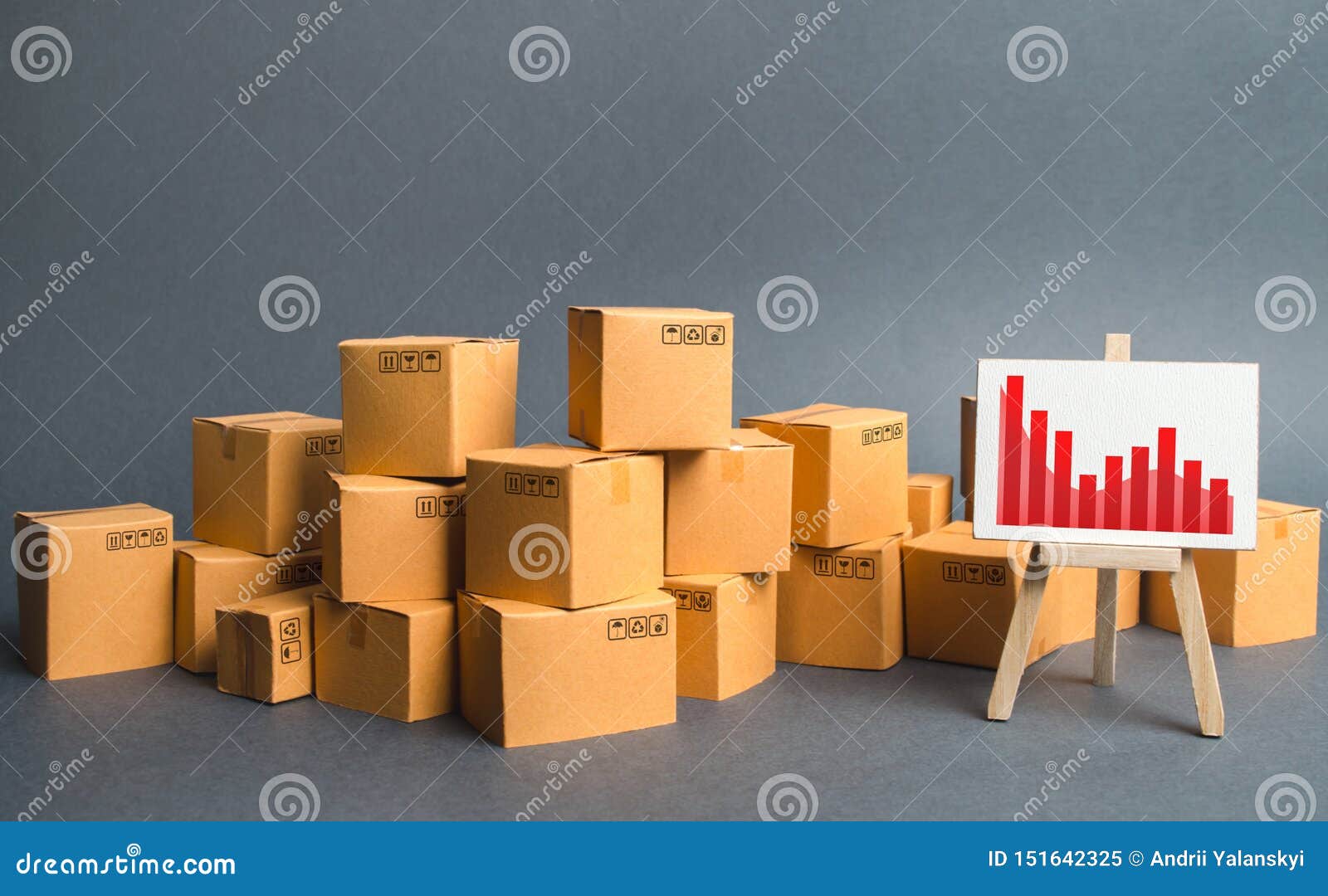 A big pile of cardboard boxes and a stand with information chart. Increasing consumer demand, exports or imports. rate growth of production of goods and products, increasing economic indicators