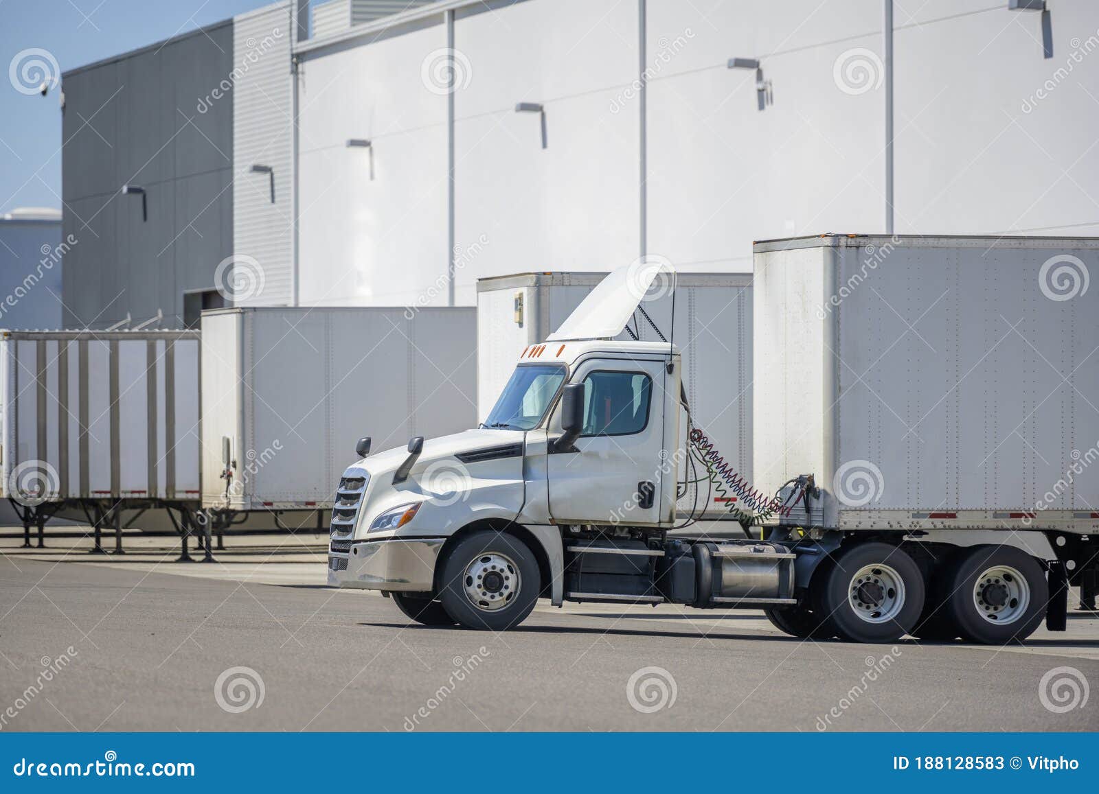 big rig commercial day cab semi truck with dry van semi trailer loading cargo at warehouse dock for the next delivery
