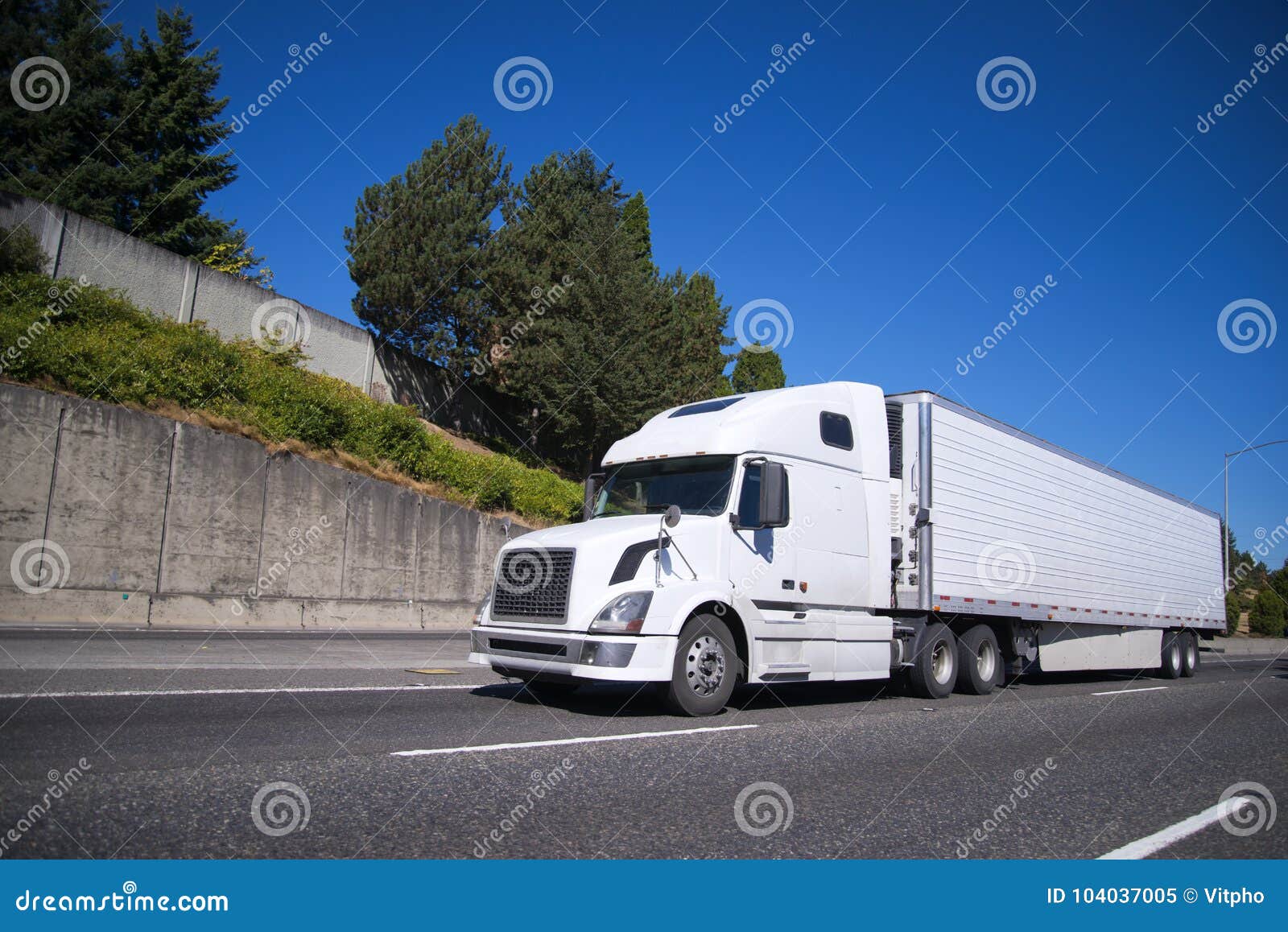 big rig semi truck with reefer semi trailer going on highway wit