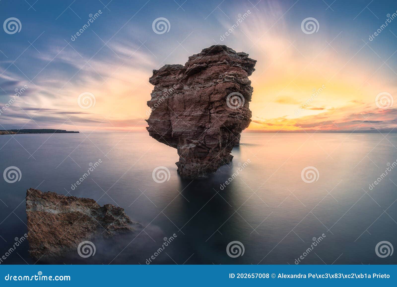 big rock on the sea at sunset