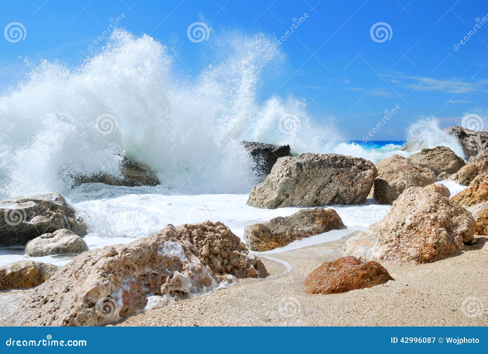 big sea wave splashing over the shore rocks