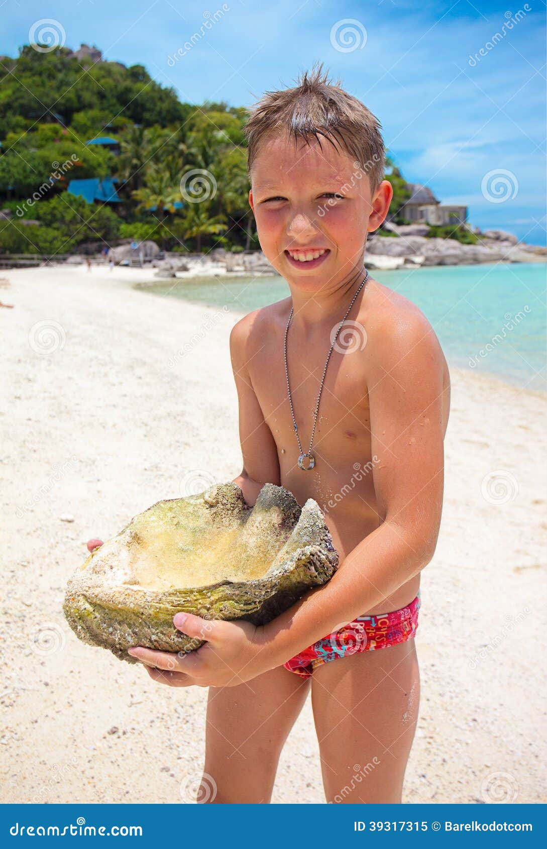 Big Seashell Held by a Young Boy on the Beach