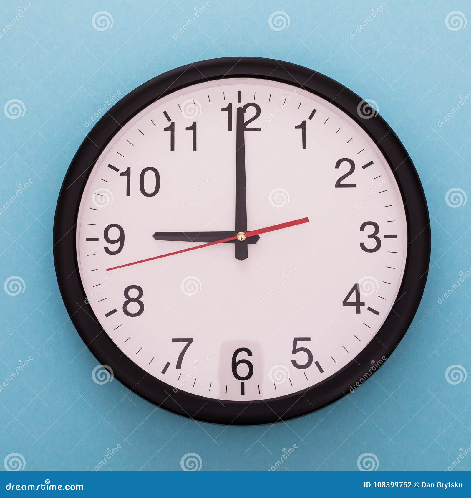 Big Wall Clock Isolated on Blue Background. Nine O`clock. Stock Photo