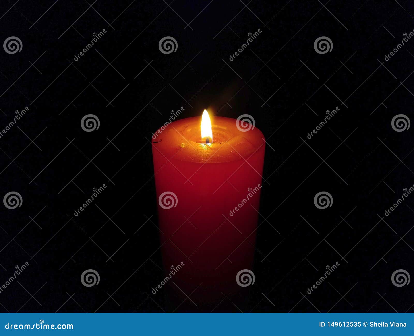 a big wax candle burning  on black background