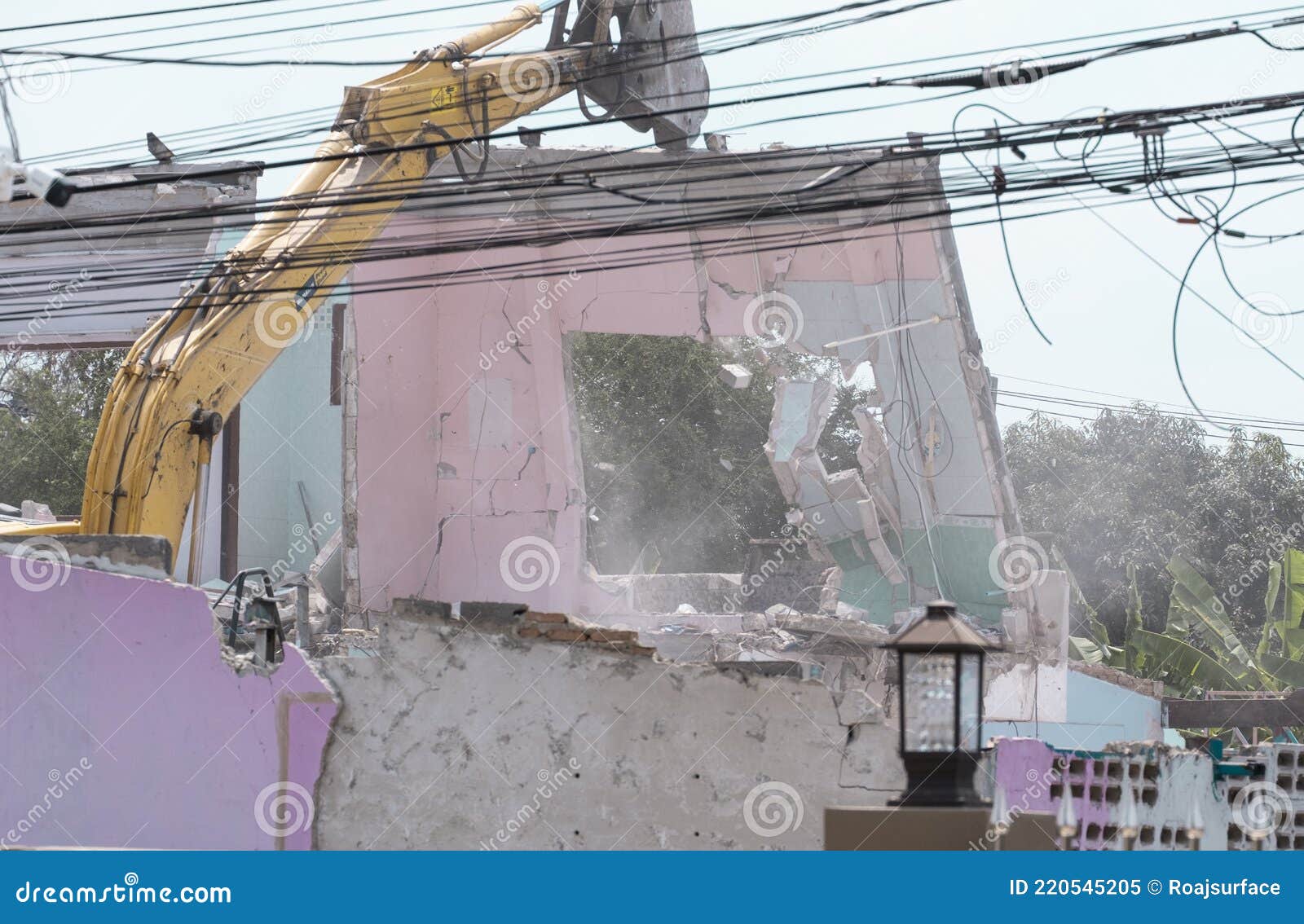 big yellow excavator removal home building by destroy pik concrete wall. uproot old construction house for development new project
