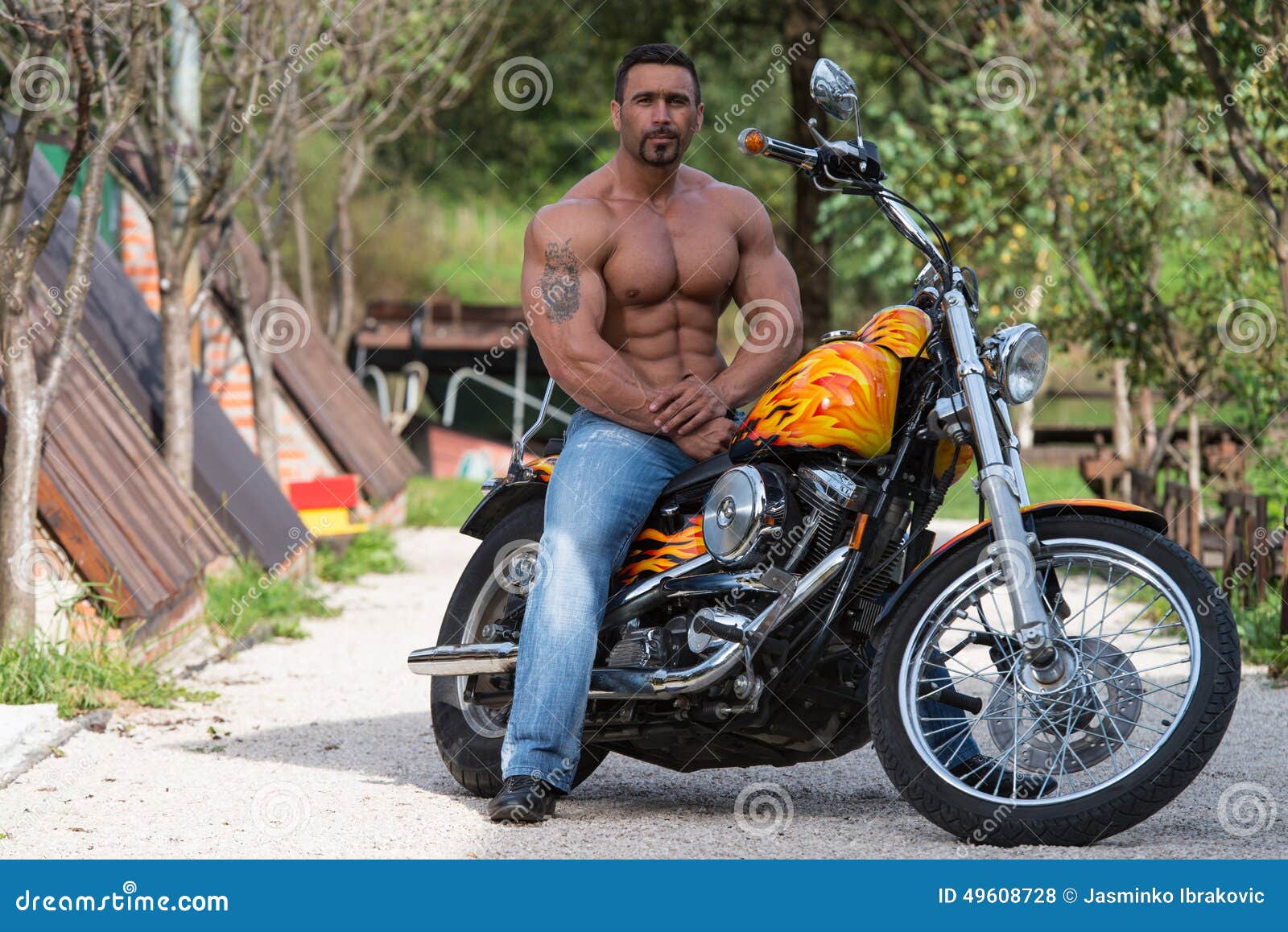 Bodybuilder Sits On A Weight Bench, He Takes A Break. Muscular Man At A