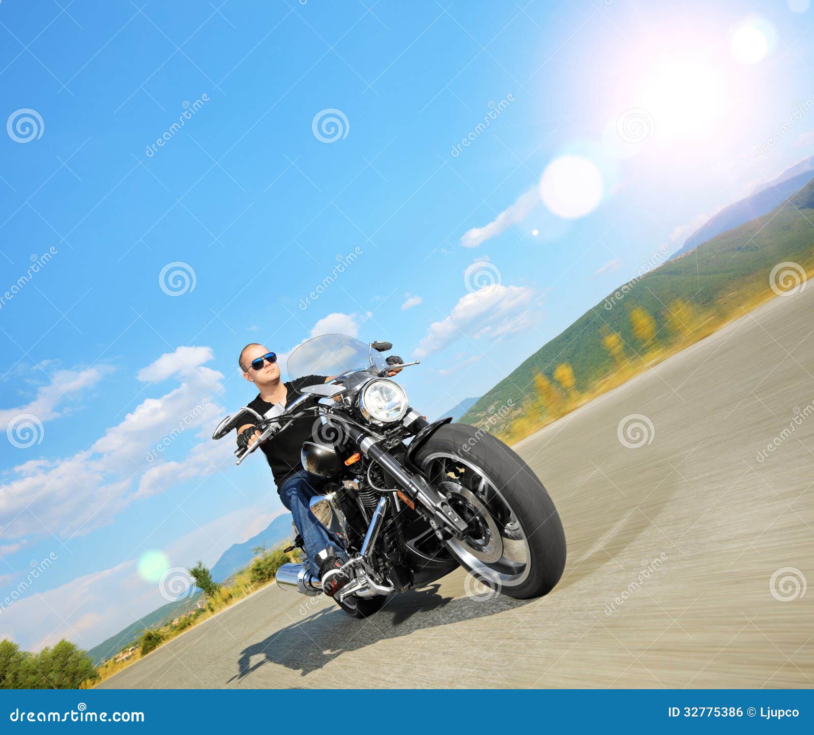 Biker Riding a Customized Motorcycle on an Open Road Stock Photo