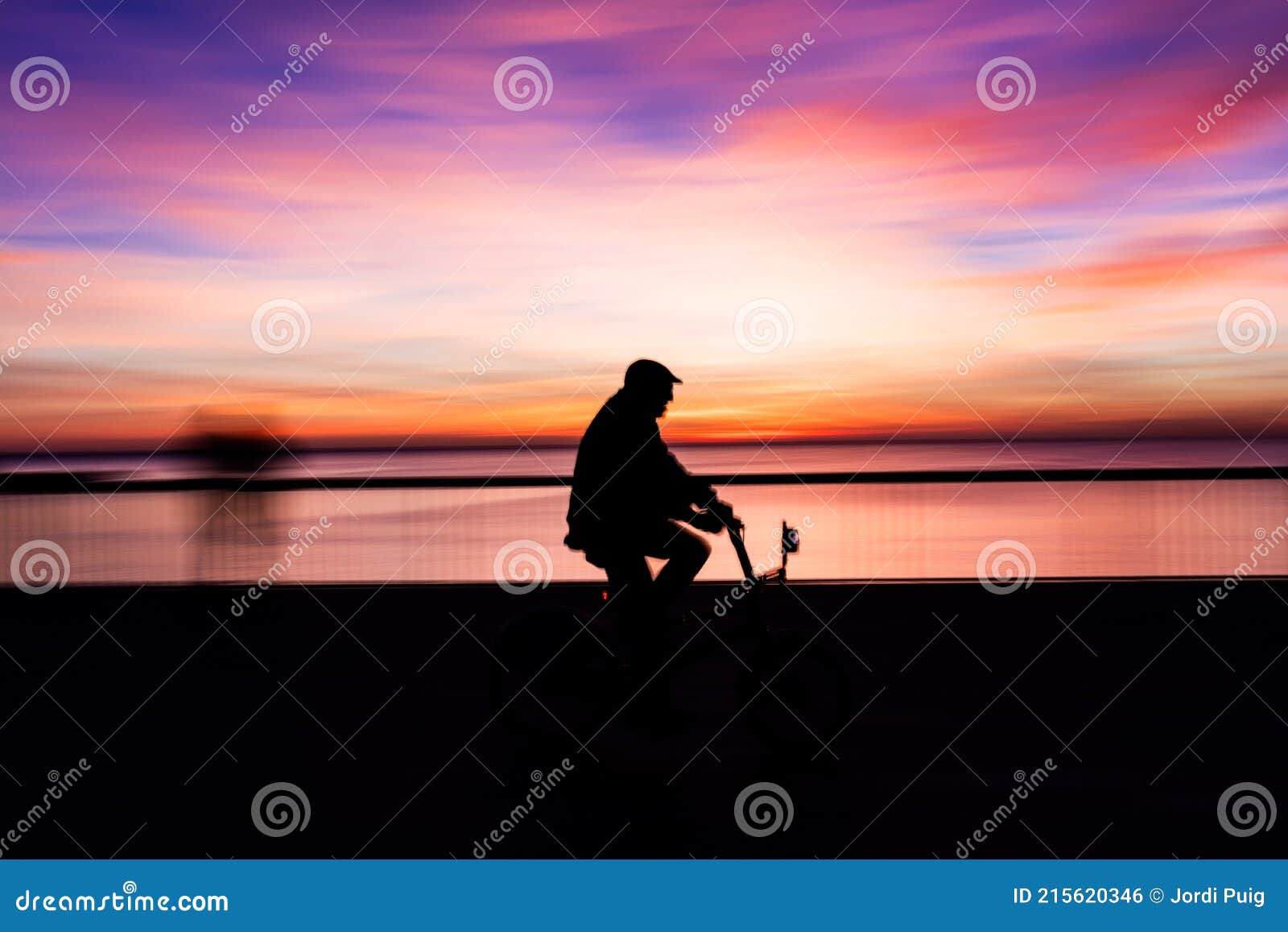 biker silhouette in la barceloneta beach at sunrise. barcelona. catalonia. spain