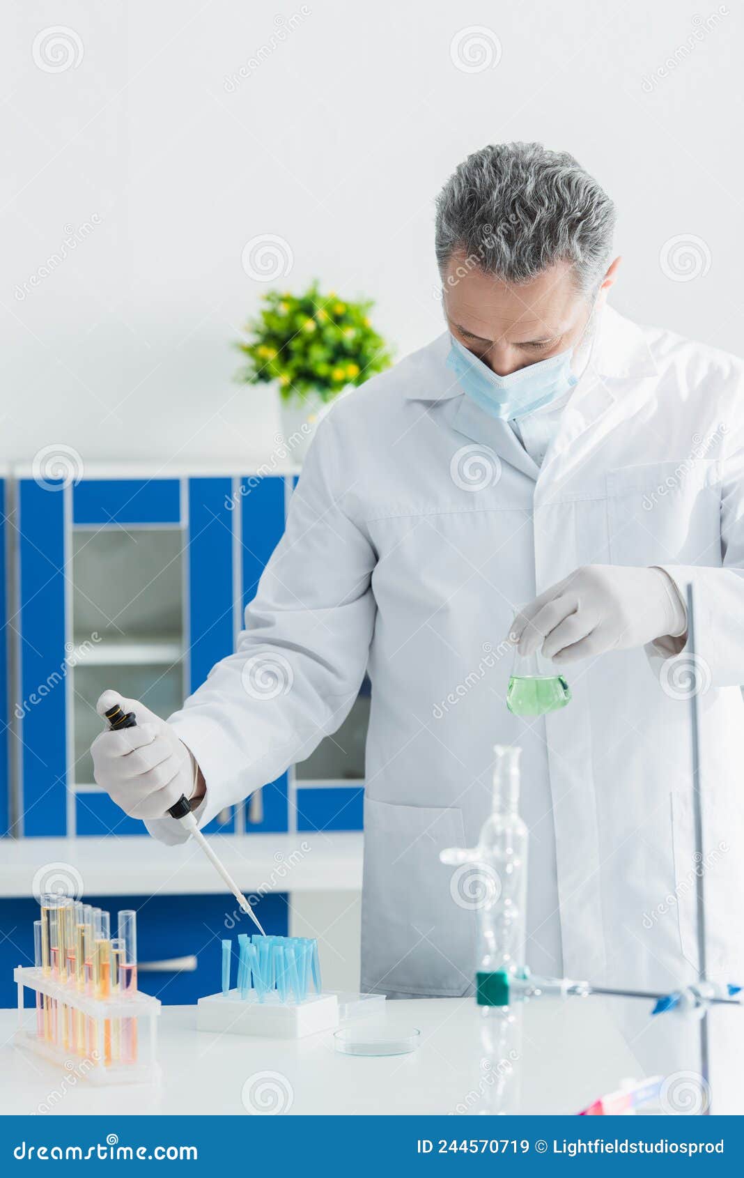 bioengineer in medical mask holding micropipette