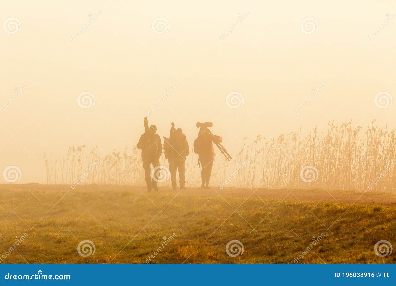 birdwatchers walking in the fog an early morning