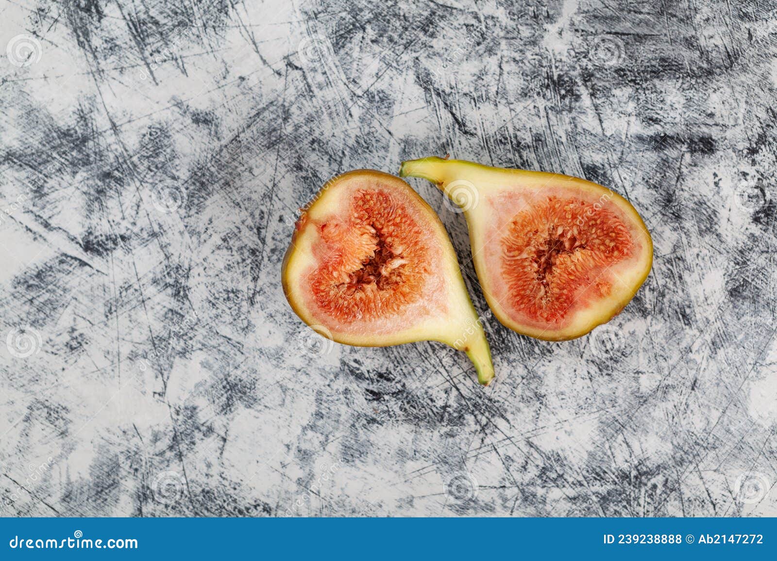 bisected unripe fig fruit on textured background. figs pulp. top view