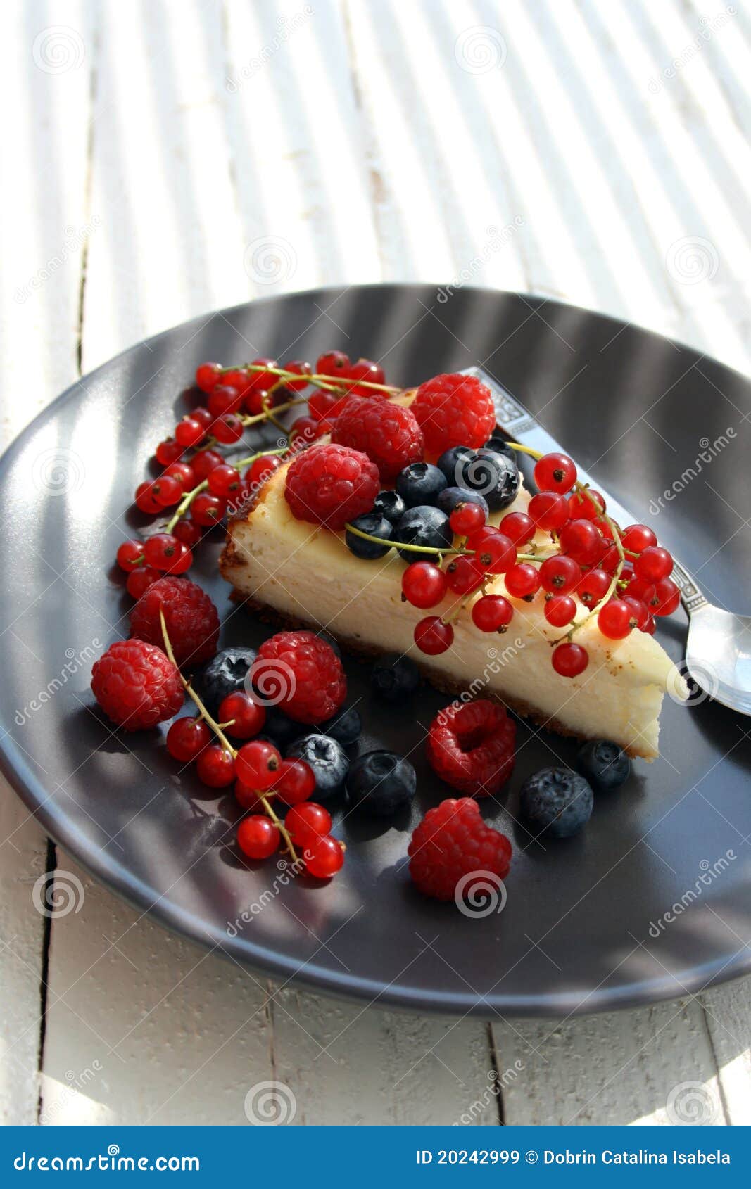 Bissen des Käsekuchens. Frischer geschmackvoller Käsekuchen mit unterschiedlicher Art der Beeren ist auf weißer Platte