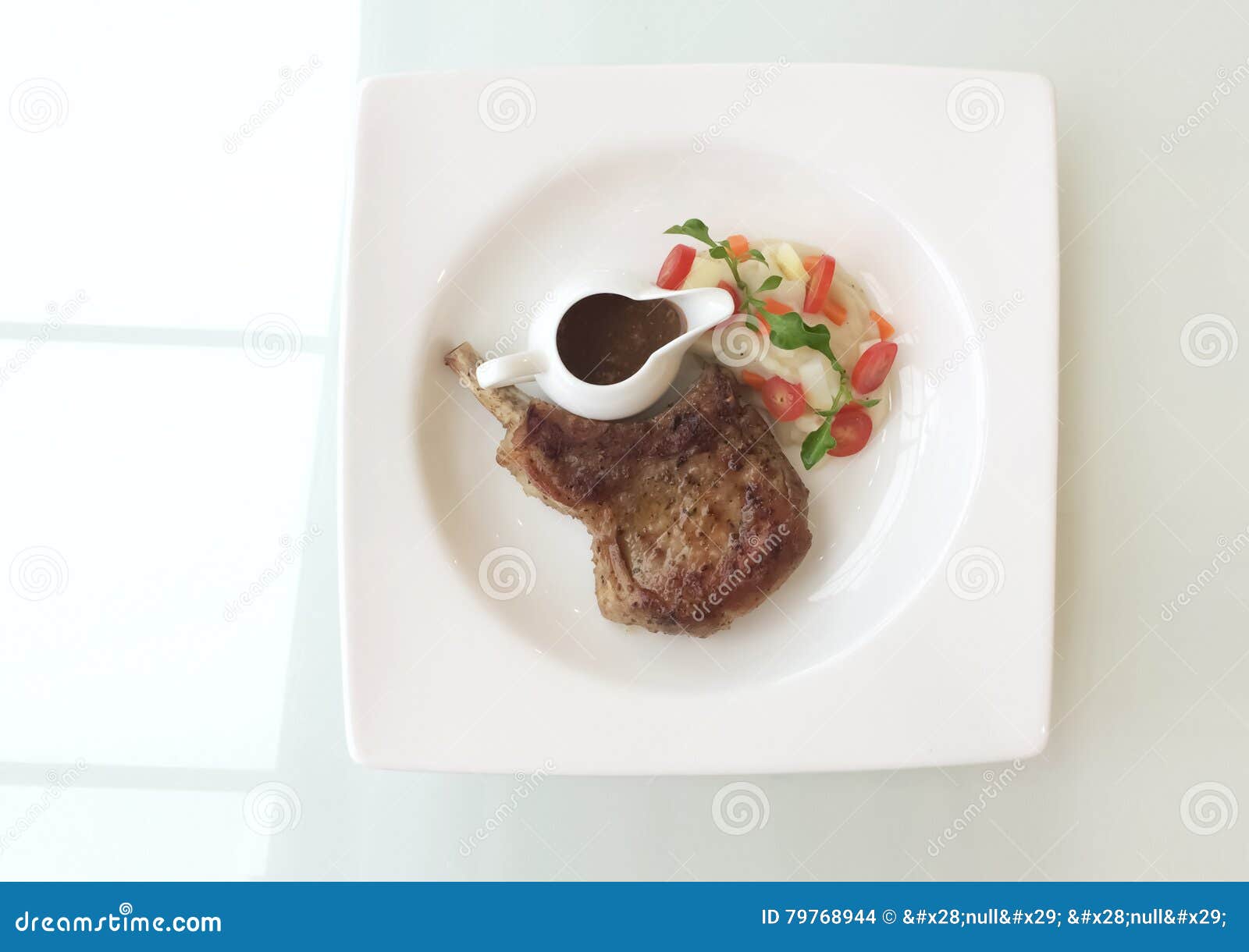 Bistecca della carne di maiale con la salsa e la verdura del sugo sulla tavola di vetro superiore