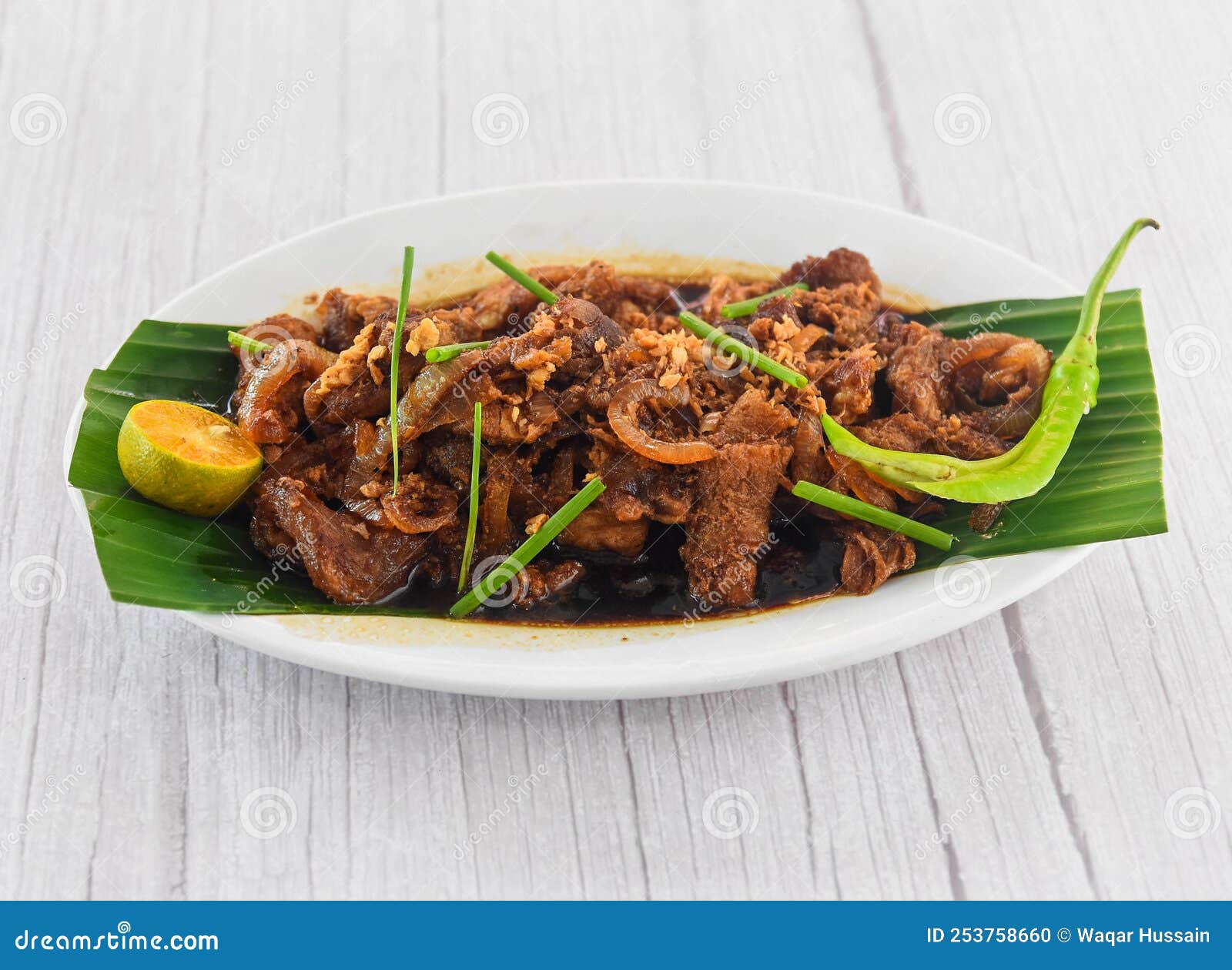bistek tagalog beef served in dish  on grey wooden background side view of fastfood