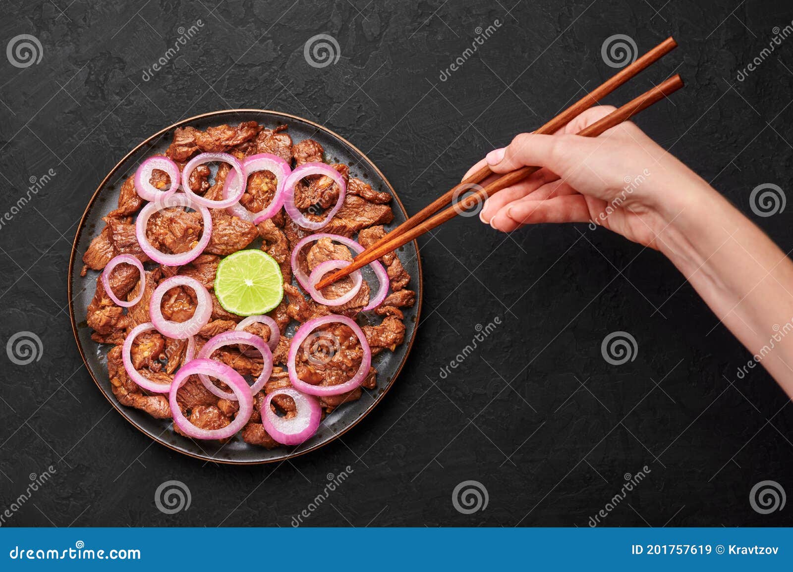 bistek tagalog or bistec encebollado on black plate on slate table top. filipino spanish cuisine beef steak with onion