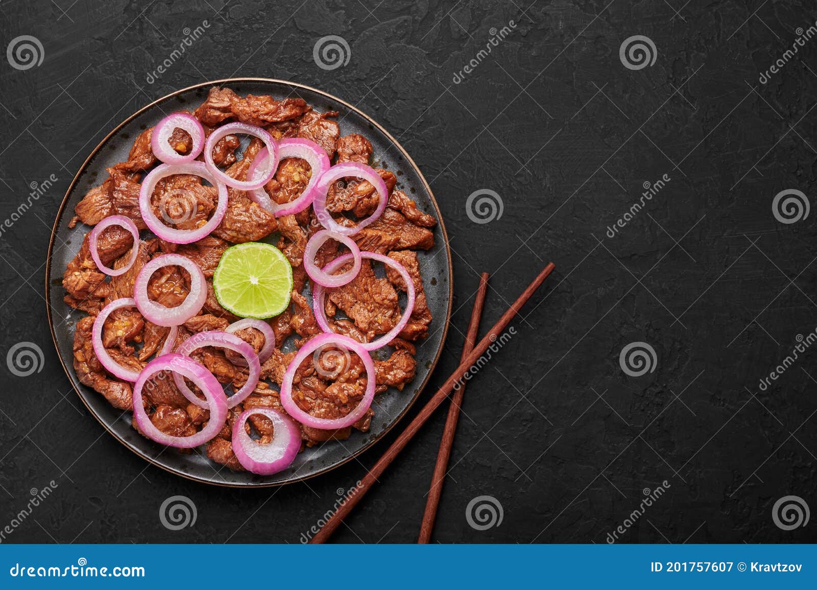 bistek tagalog or bistec encebollado on black plate on slate table top. filipino spanish cuisine beef steak with onion