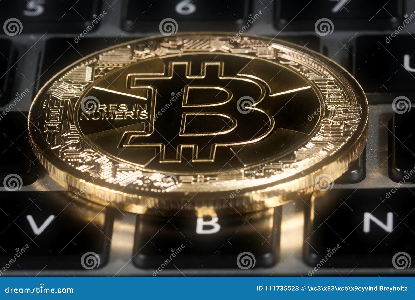 bitcoin positioned on top of keyboard.