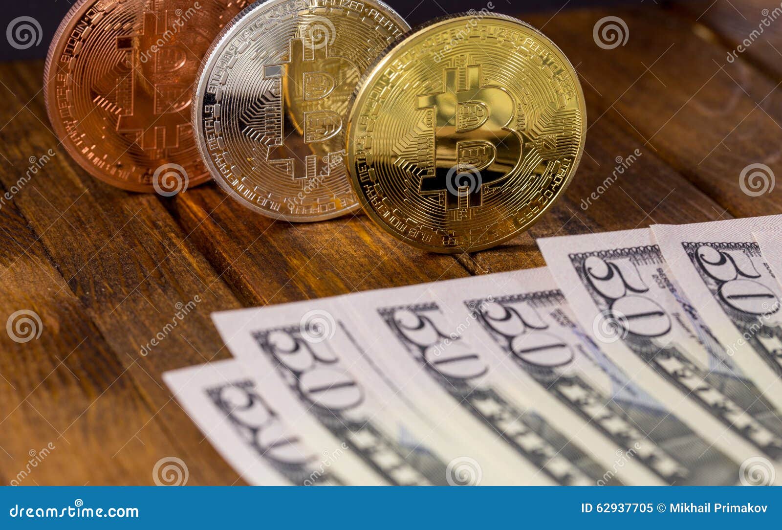 Τρία bitcoins με τα δολάρια στο ξύλινο υπόβαθρο