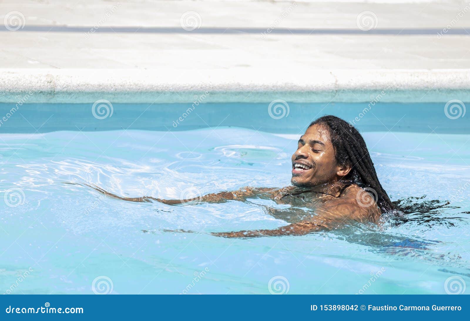 Black AfricanAmerican with Dreadlocks Swimming in a Pool Stock Photo