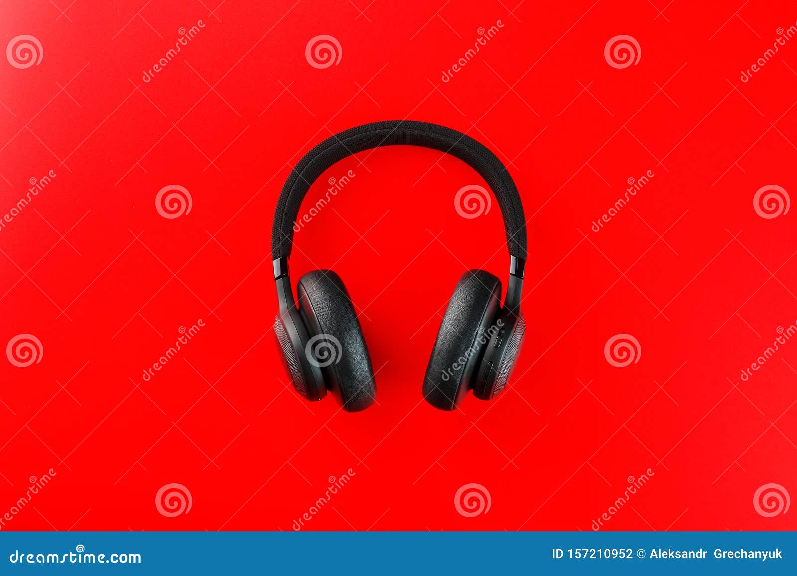 Black Bluetooth Headphones on a Red Background Top View. inEar