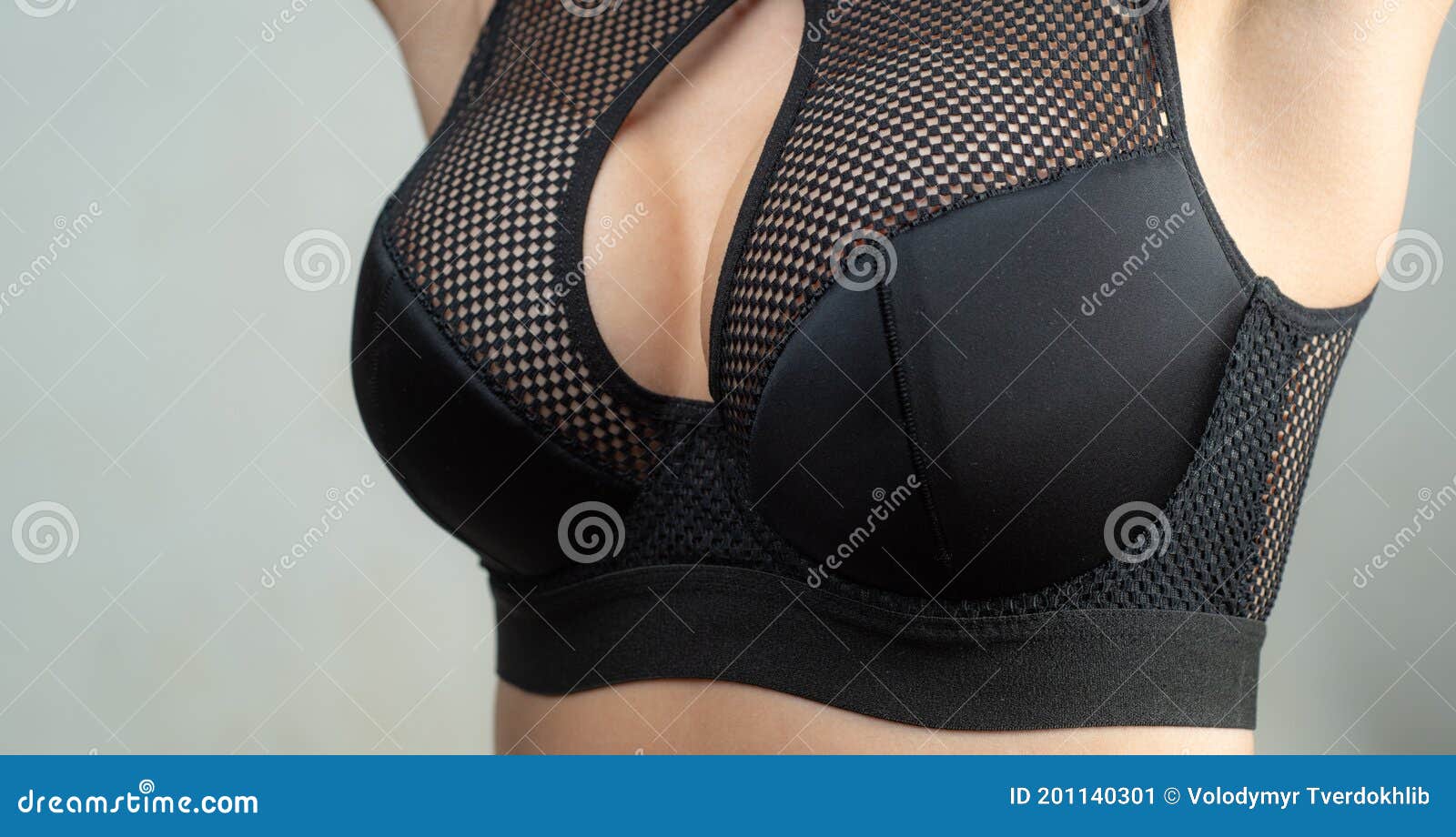 Young Blonde Woman Trying On Black Push Up Bra. Bosom Concept