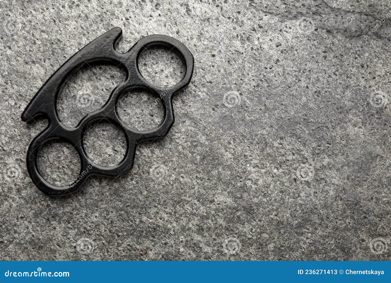 Black Brass Knuckles on Grey Background, Top View. Space for Text