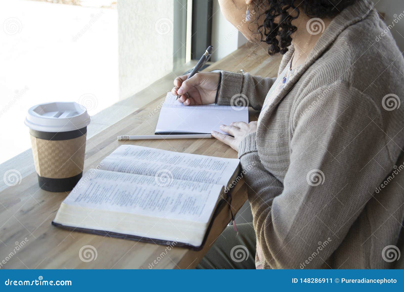 black woman studies her bible and takes notes
