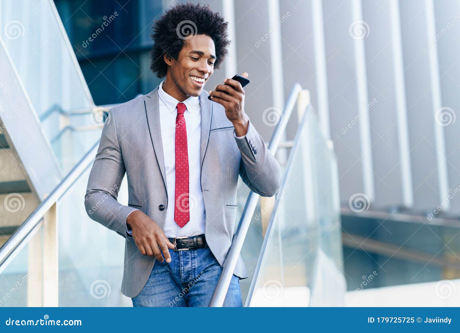 black businessman using a smartphone near an office building