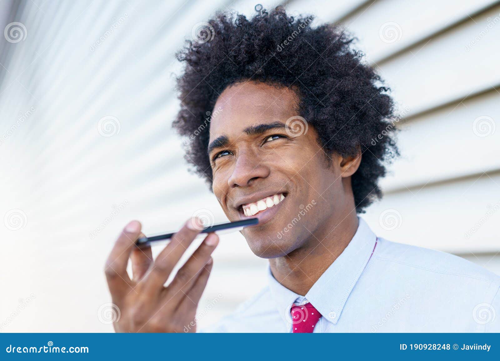 black businessman using a smartphone near an office building