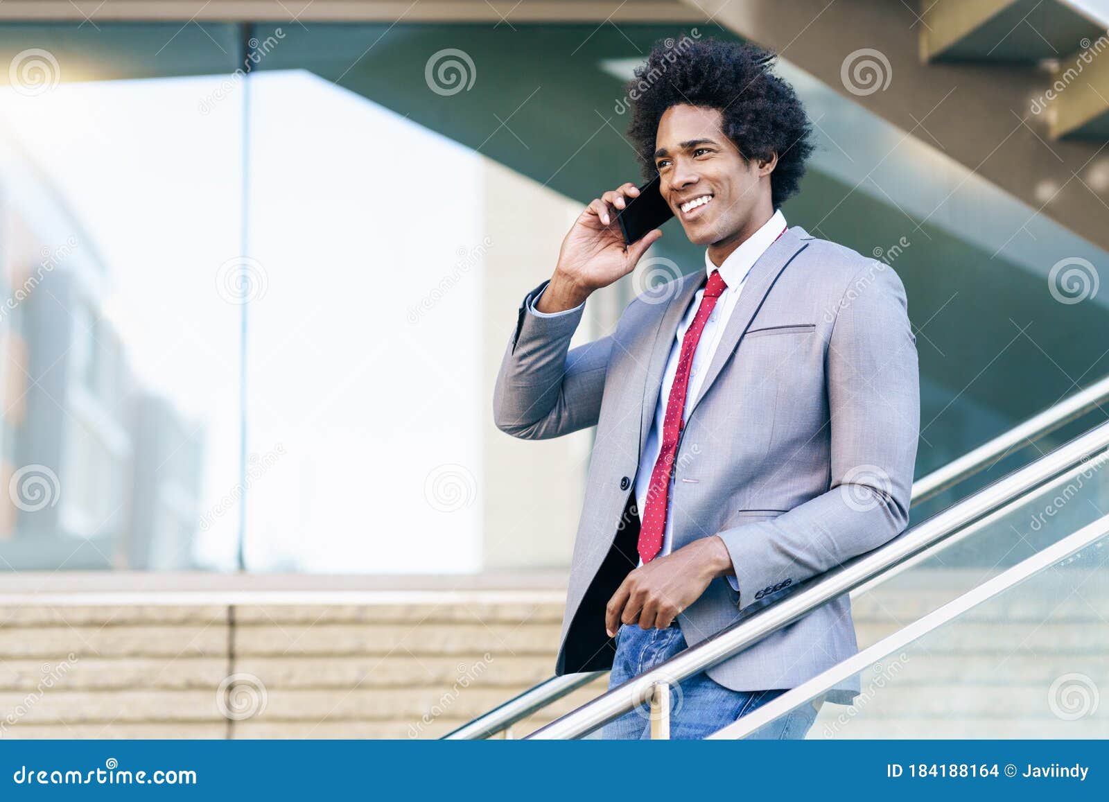 black businessman using a smartphone near an office building