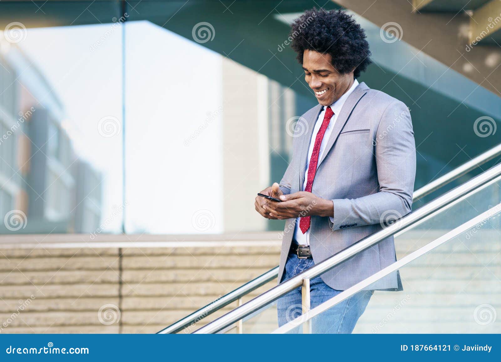 black businessman using a smartphone near an office building