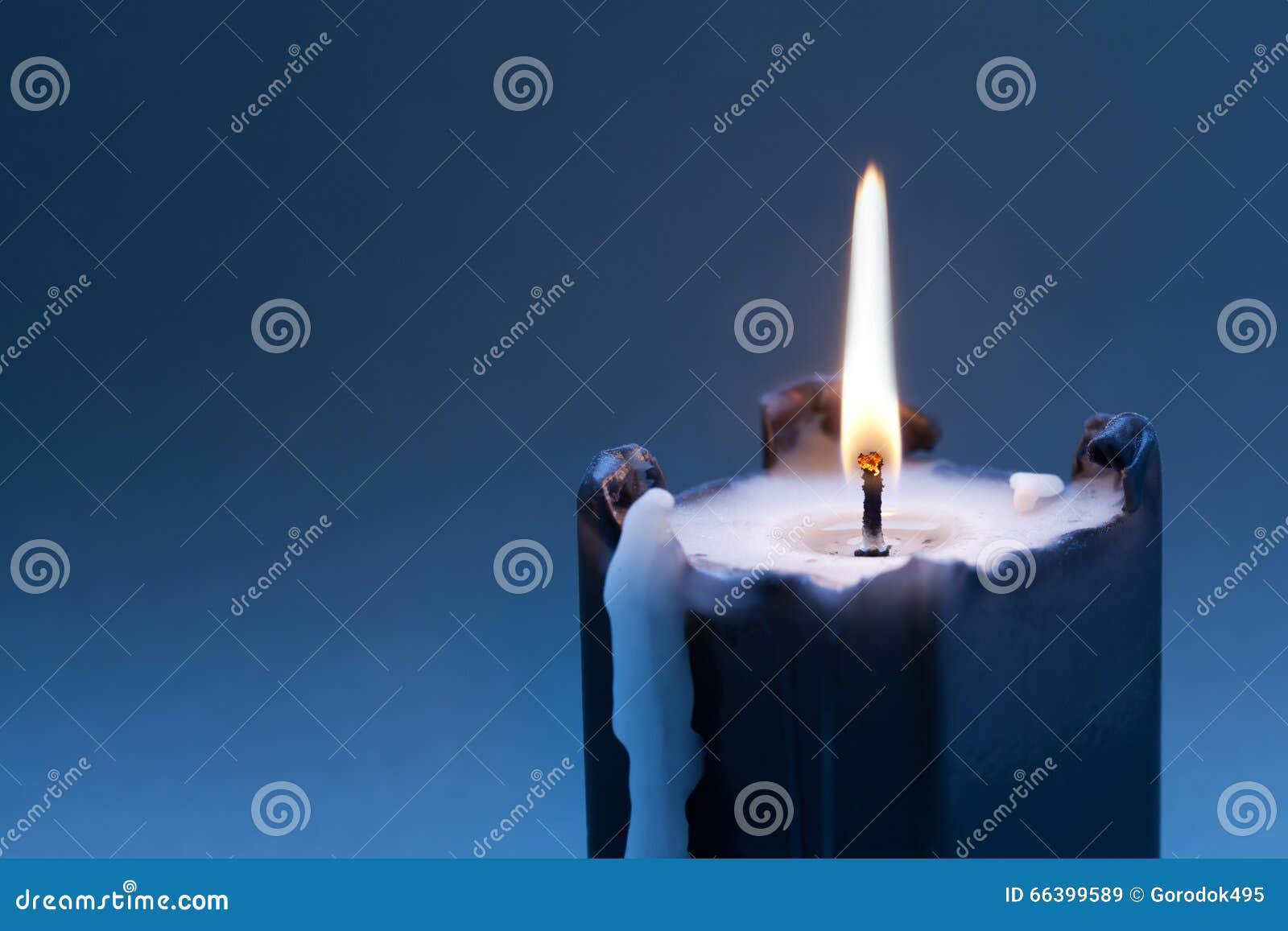 Black Candle With Burning Wick On Dark Blue Gradient Background. Copy